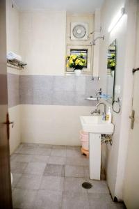 a bathroom with a sink and a toilet and a window at Divine India Service Apartment 3Bhk 1B Saket in New Delhi