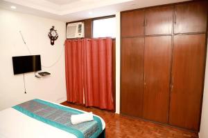 a bedroom with a bed and a red curtain at Divine India Service Apartment 3Bhk 1B Saket in New Delhi