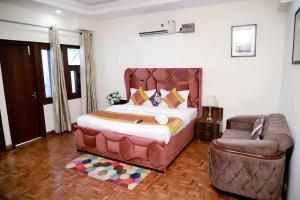 a bedroom with a large bed and a couch at Divine India Service Apartment 3Bhk 1B Saket in New Delhi
