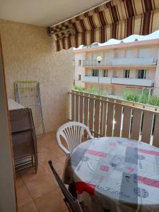 een balkon met een tafel en stoelen en een gebouw bij Charmant appart. 500m plages des Sablettes in La Seyne-sur-Mer