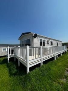 un camper bianco con portico e ringhiera bianca di Newquay Bay Resort - Summer Days 135 a Newquay Bay Resort