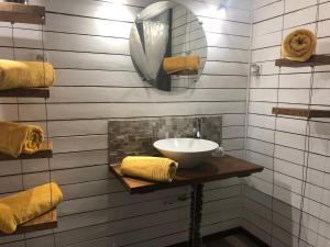 bagno con lavandino, specchio e asciugamani di La Maison a La Chapelle-Saint-Martin-en-Plaine
