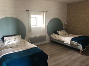 een slaapkamer met 2 bedden en een raam bij La Maison in La Chapelle-Saint-Martin-en-Plaine