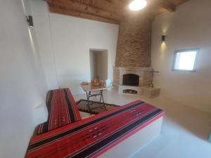 Tafileh-Sila'a Heritage Village في الطفيلة: غرفة بها موقد ومقعد احمر في غرفة