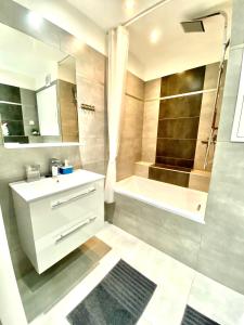 uma casa de banho com um lavatório, uma banheira e um chuveiro em Marcus- Modern Relaxing apartment em Děčín