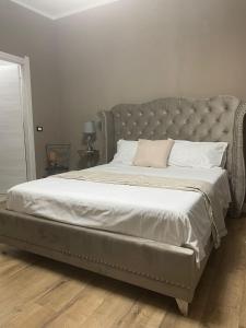 a bed in a bedroom with a gray tufted bed frame at claire de lune in Cagliari