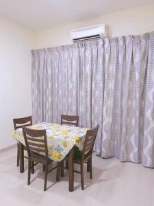 a dining room table with four chairs and a heater at IJM Homestay Condominium in Sandakan