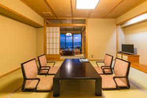 een vergaderzaal met een tafel en stoelen bij Yuzanso in Otsu