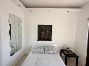 - une chambre blanche avec un lit et un tableau mural dans l'établissement Accommodation Tomcuk, à Kotor