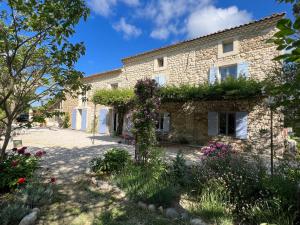 a stone house with flowers in front of it at Mas de l'Estiou in Monteux