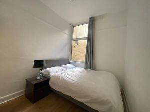sypialnia z białym łóżkiem i oknem w obiekcie barnet 2 w mieście Barnet
