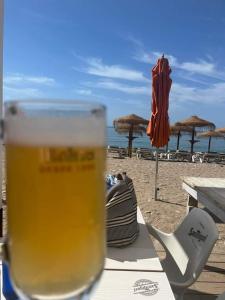 un vaso de cerveza sentado en una mesa en la playa en Apartamentos Playamar en Isla Plana