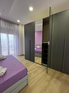 - une chambre avec un lit violet et un miroir dans l'établissement Renovated Loft with Vesuvio view terrace, à Scafati