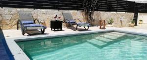 a swimming pool with two chairs and a table and a table at Villa Iliogioma with private pool and sea view in Katomérion