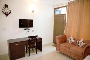 een woonkamer met een bank, een bureau en een televisie bij Divine India Service Apartment 3Bhk, 2B Saket in New Delhi