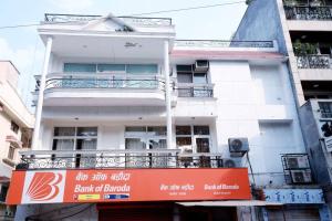 un bâtiment blanc avec un panneau orange devant lui dans l'établissement Divine India Service Apartment 3Bhk, 2B Saket, à New Delhi