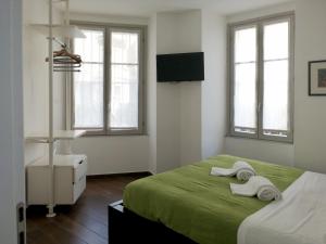 a bedroom with two towels on a bed with windows at Al Molo 2 in Como