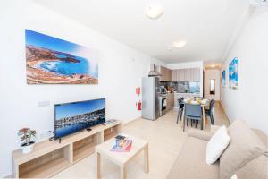 a living room with a couch and a table at Islet Promenade Seafront Family Apartment with 2 balconies by Getawaysmalta in St Paul's Bay