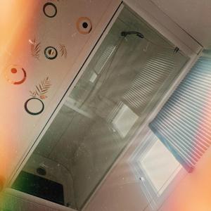 una ducha con una puerta de cristal junto a una ventana en Vacances insolites en Foix