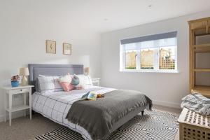a bedroom with a bed with a person laying on it at The Hideaway, Modern 3 bed in Tintagel, Cornwall in Tintagel