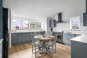 a kitchen with a table and chairs in it at The Hideaway, Modern 3 bed in Tintagel, Cornwall in Tintagel