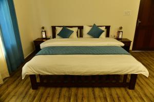 ラムナガルにあるCorbett wala by ayu villaのベッドルーム(青い枕の大型ベッド1台付)