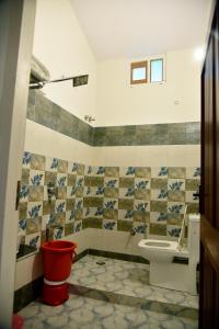ラムナガルにあるCorbett wala by ayu villaのバスルーム(トイレ、赤いゴミ箱付)