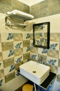a bathroom with a white sink and a mirror at Corbett wala by ayu villa in Rāmnagar