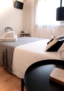 1 dormitorio con 1 cama con manta blanca y negra en Barcelona PR Guesthouse, en El Prat de Llobregat