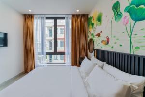 um quarto com uma grande cama branca e uma janela em Q Boutique Hotel em Nha Trang