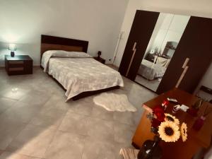 1 Schlafzimmer mit einem Bett, 2 Tischen und einem Spiegel in der Unterkunft Stupor Mundi in Bitritto