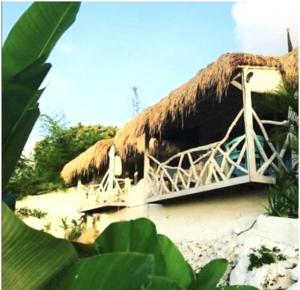 a hut with a straw roof on a beach at Gravity Eco Boutique Hotel - Adults Only in Uluwatu