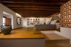 1 dormitorio con 1 cama y un jarrón en el suelo en Pera houses 2-bedroom in the center of Lindos, en Lindos