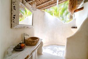 a bathroom with a sink and a mirror at Gravity Eco Boutique Hotel - Adults Only in Uluwatu