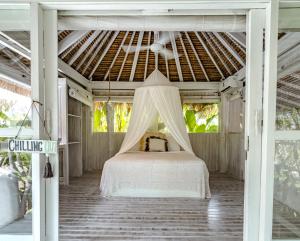 a bed in a covered porch with a canopy at Gravity Eco Boutique Hotel - Adults Only in Uluwatu