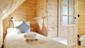 a bedroom with a bed in a wooden wall at Pokoje i Domki Na Szlaku in Polanica-Zdrój