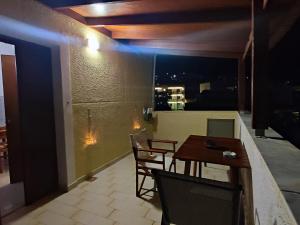 a room with a table and chairs on a balcony at Captain's Mermaid Houses, Karpathos in Karpathos Town