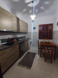 una cocina con armarios de madera y una mesa con mesa. en Captain's Mermaid Houses, Karpathos, en Karpathos