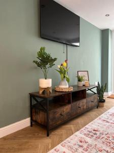 a living room with a tv on a wall at Cherry Blossom cottage in Old Glossop