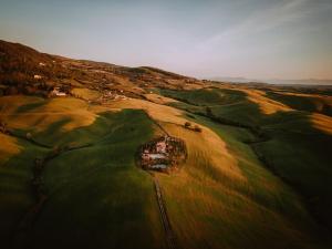 z góry widok na pole golfowe z domem w obiekcie AGRITURISMO LUCERTOLA w mieście Montecatini Val di Cecina