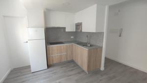 an empty kitchen with a sink and a refrigerator at Apartamentos Plateria in O Grove