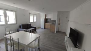 a living room with a dining room table and a kitchen at Apartamentos Plateria in O Grove