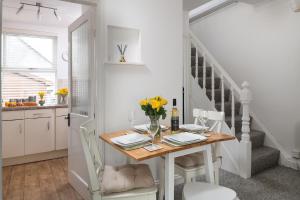 a kitchen and dining room with a table and chairs at Bron Eryri - Our Cosy House opposite the entrance to Portmeirion! in Mynfford