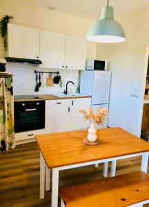a kitchen with a wooden table and a kitchen with white appliances at Gîte Clair de Lune in Monts-sur-Guesnes