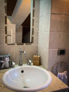 een wastafel in een badkamer met een grote spiegel bij Etna Green in Ragalna