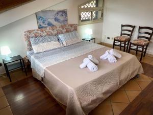 een slaapkamer met een groot bed en handdoeken bij Etna Green in Ragalna