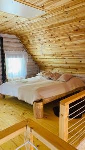 1 cama en una cabaña de madera con ventana en Tisza-Parti Rönkház Tokaj, en Rakamaz