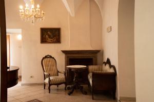 a living room with two chairs and a fireplace at Gasthof zur Post in Egna