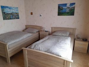 2 Betten in einem Schlafzimmer mit Gemälden an der Wand in der Unterkunft Ferienwohnung Wölbert in Altendiez
