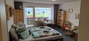 Schlafzimmer mit einem Bett, einem Tisch und einem Fenster in der Unterkunft Ferienwohnung deine Auszeit im Allgäu in Missen-Wilhams